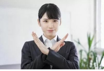 身体の前で手でバッテンの形を作り注意している画像